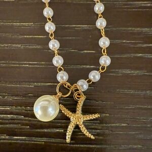 Classy, faux pearl necklace with starfish and small pearl charms.